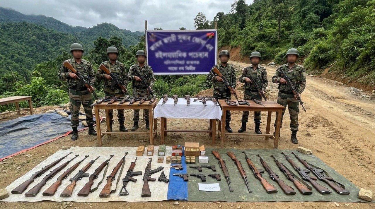 Security personnel displaying recovered illegal weapons during an arms recovery operation in Manipur