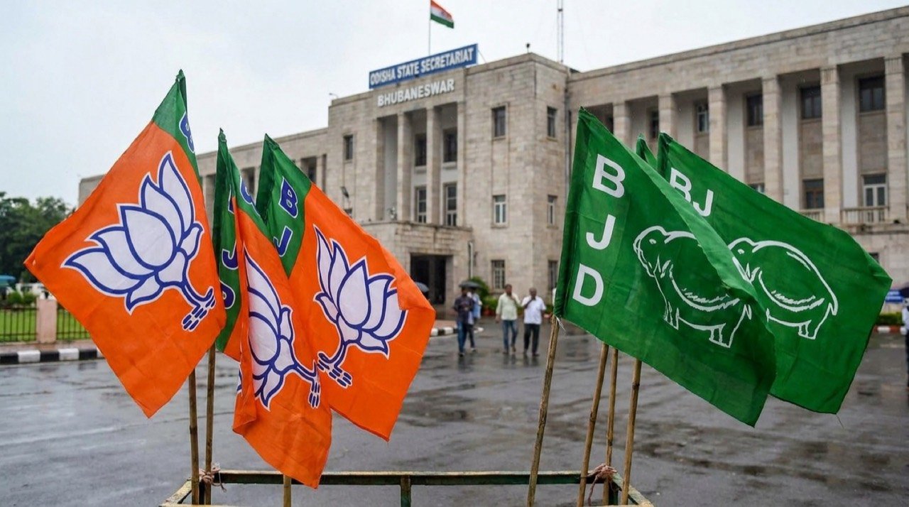 Political party flags against the Odisha state secretariat backdrop, illustrating BJP claims about possible BJD defections